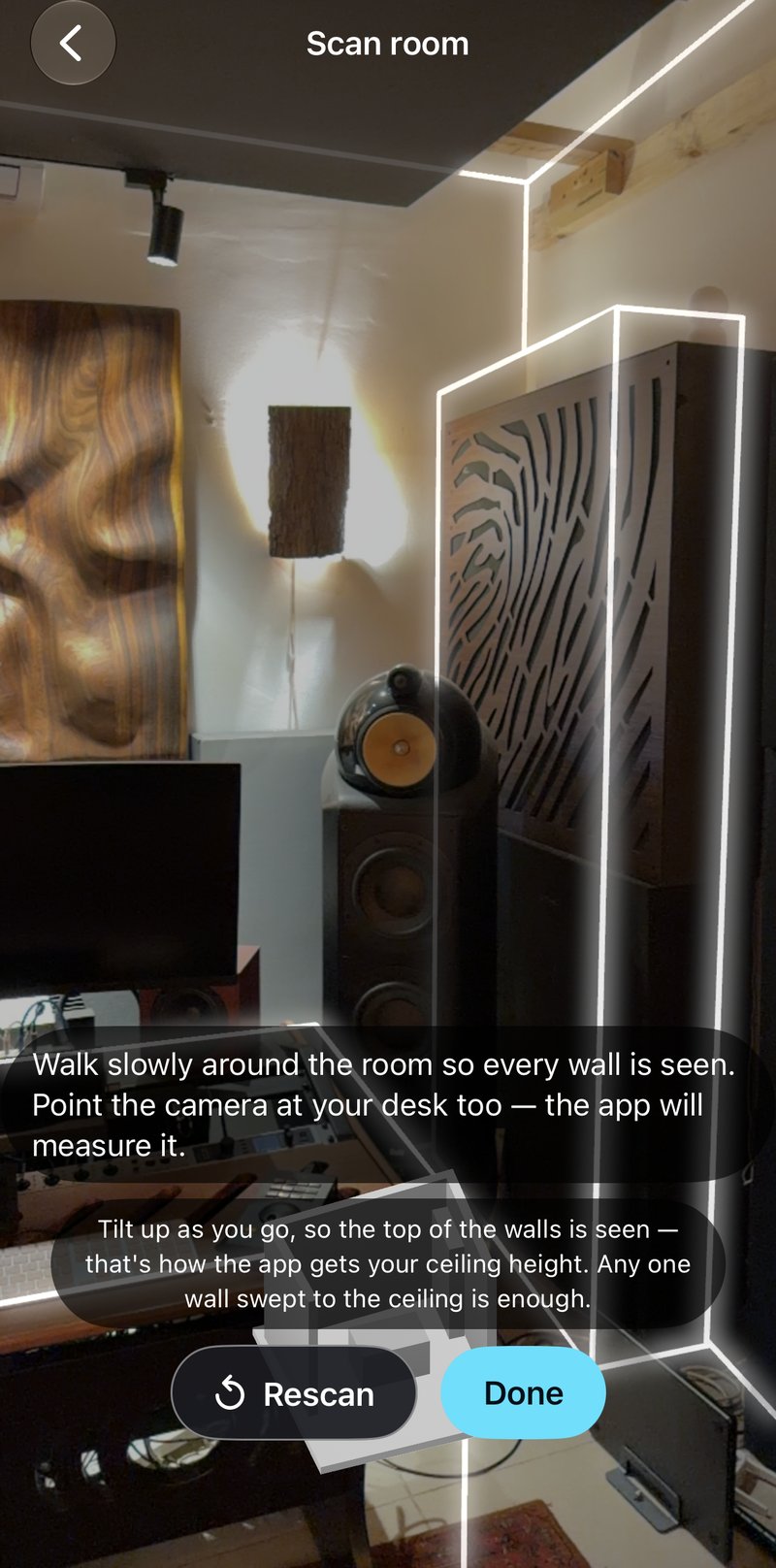 The scan screen: a live camera view of a studio with its walls and a speaker cabinet outlined in white by LiDAR.
